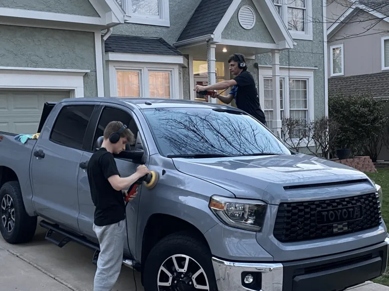Aqulux team polishing a truck in a driveway